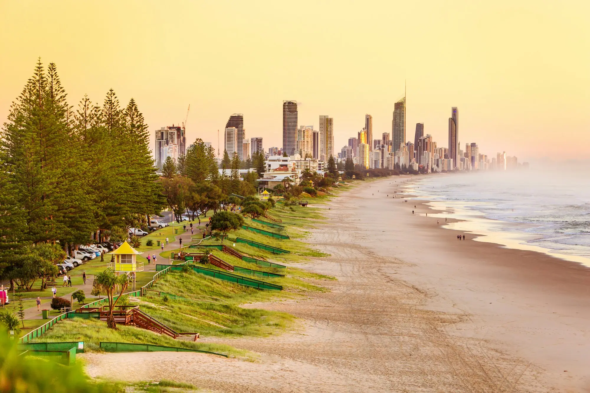 Beachgoers in front of Gold Coast high-rise towers on a sunny day