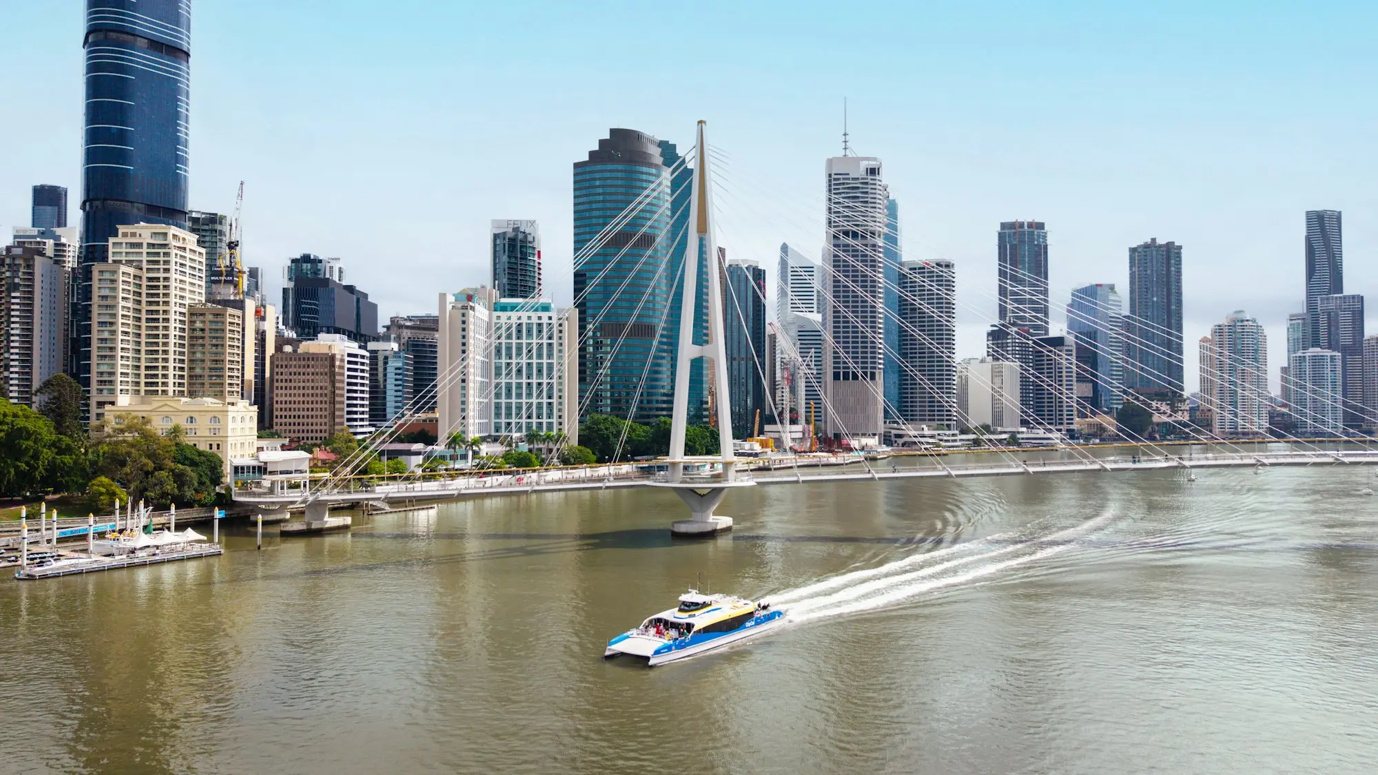 A ferry travelling on the Brisbane River beneath the Kurilpa Bridge