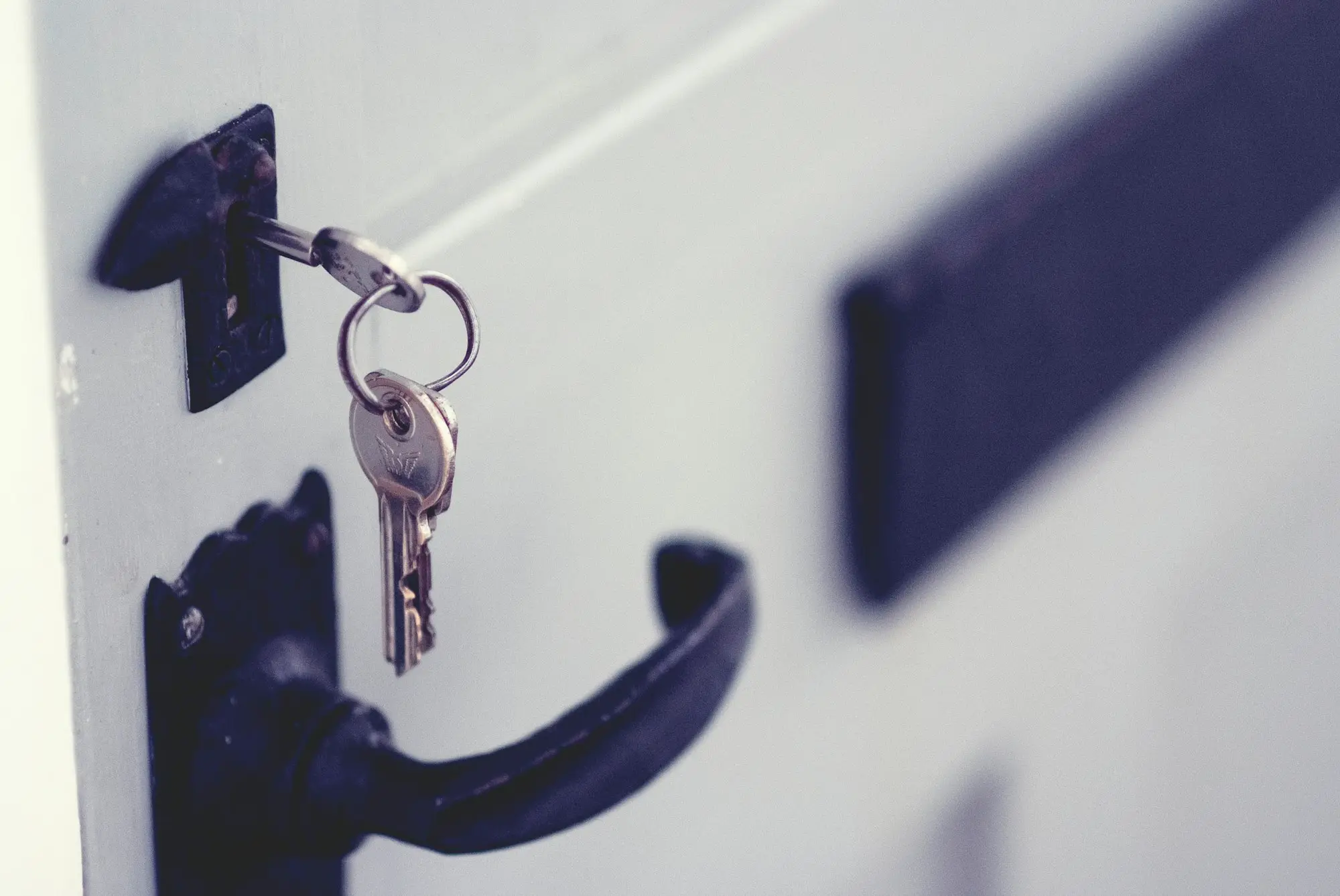 Black and silver padlock on a white door, a symbol of secured lending