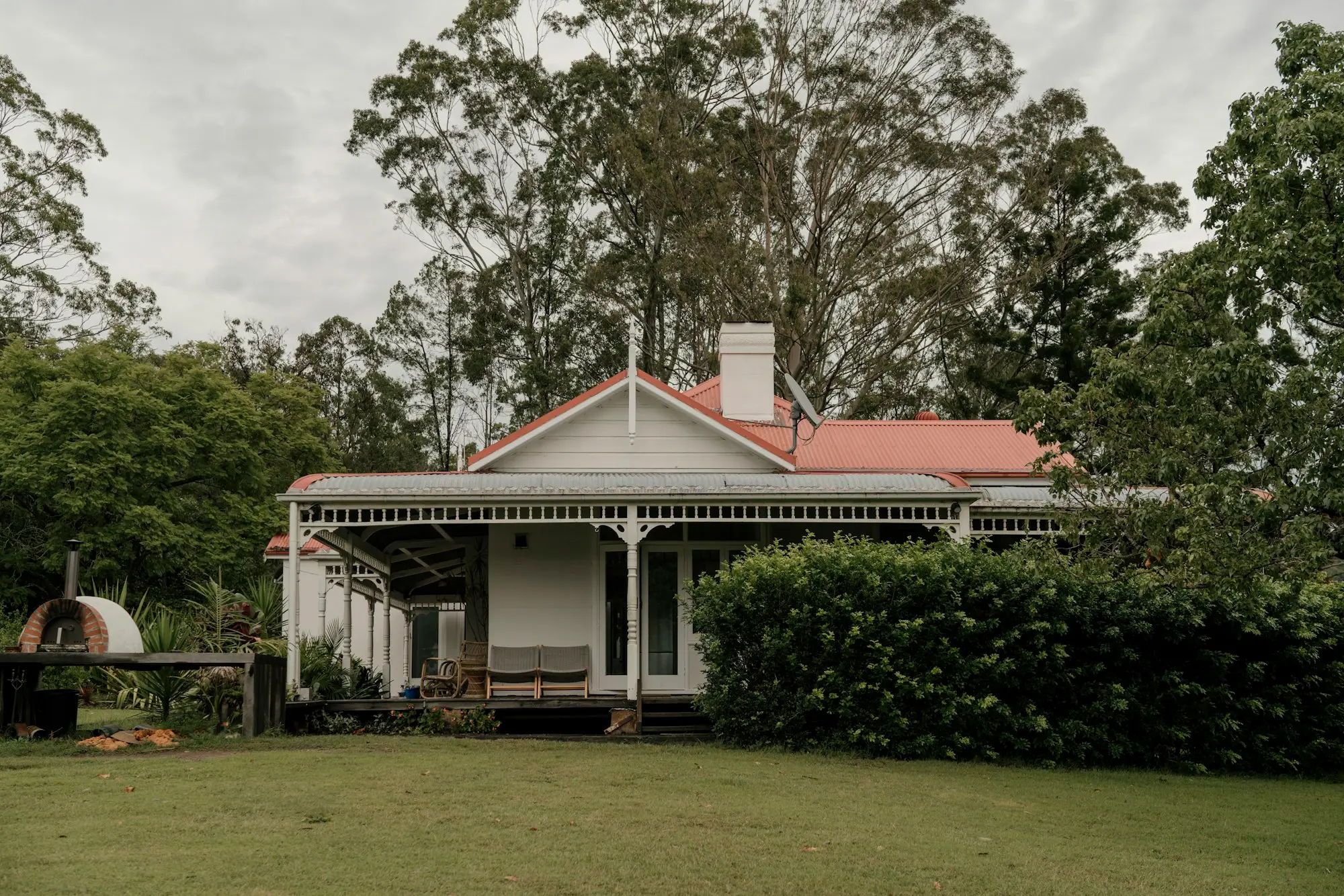 White house with a red roof surrounded by trees