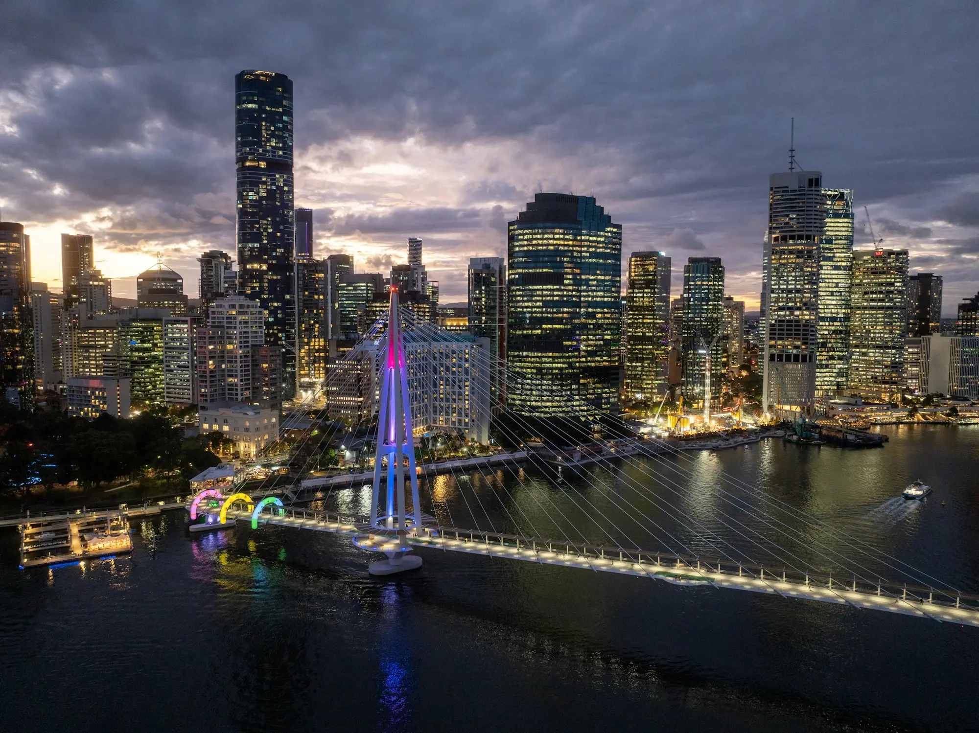 Brisbane skyline with an illuminated bridge at dusk